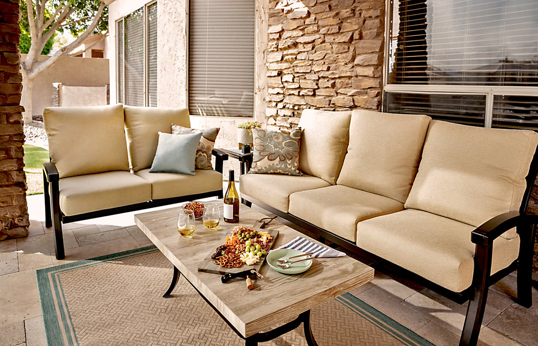 Beige colored sofas with area rug and coffee tabes outdoors