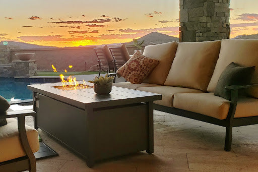 firepit next to a couch on a patio at sunset