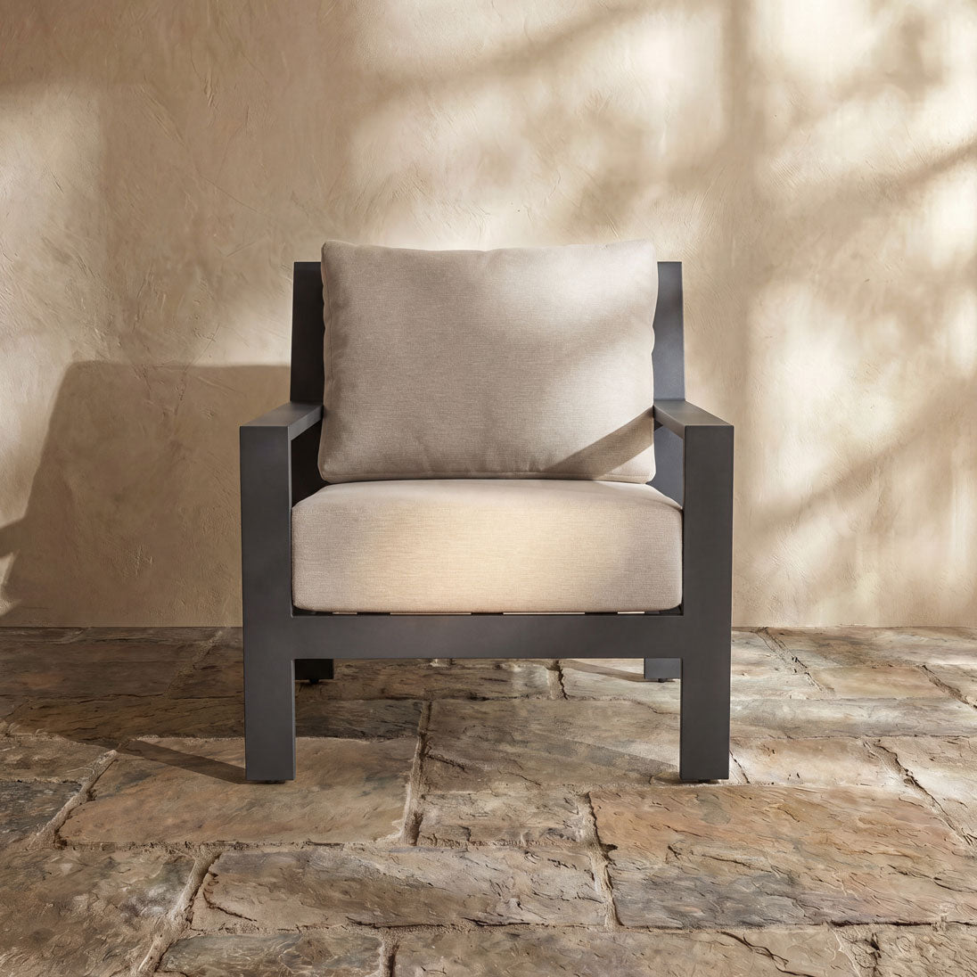 Paddy O' furniture club chair with dark geometric frame and soft oatmeal-colored upholstery.