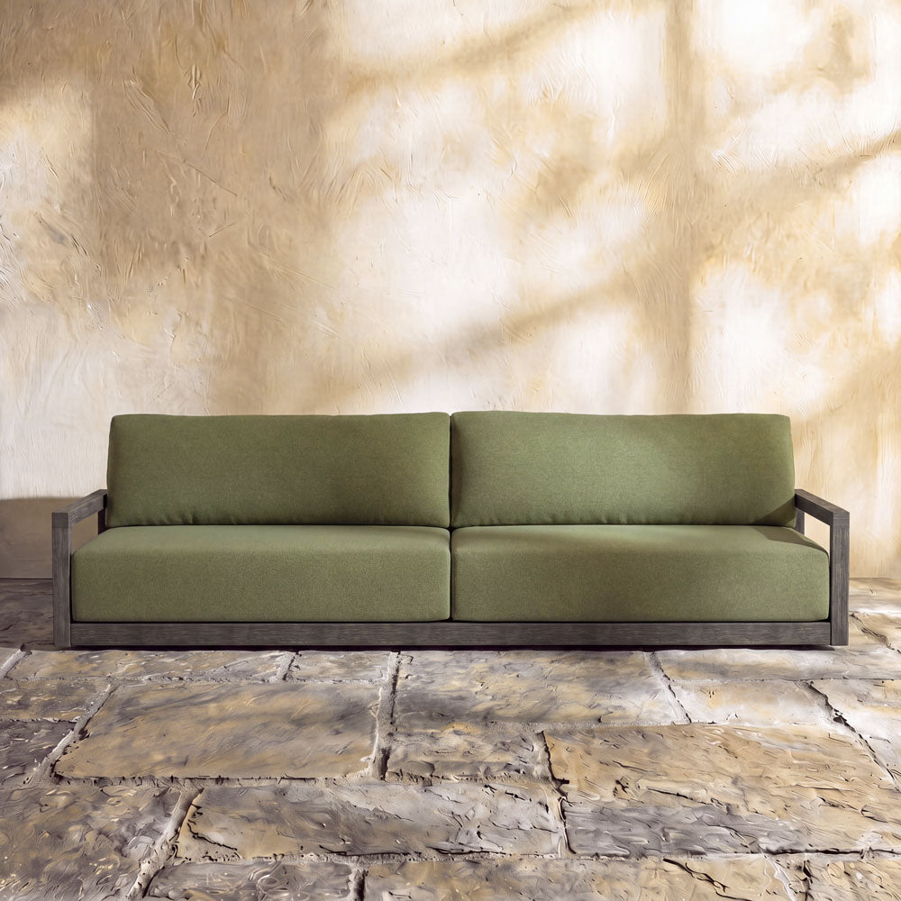 A single, low-profile sofa with a dark grey or weathered wood frame.