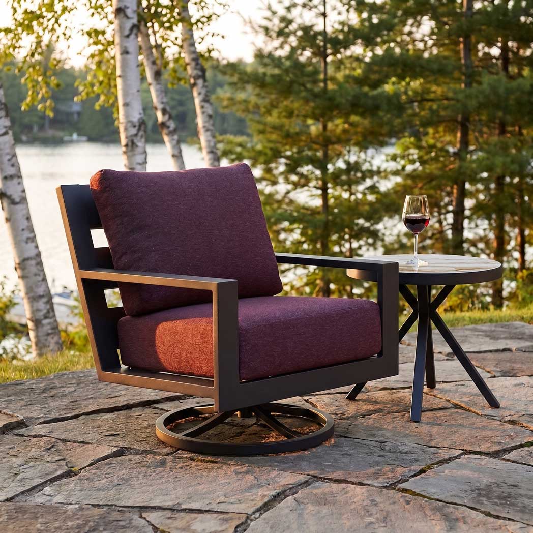 Peninsula Club Swivel chair with deep purple cushions on a stone patio overlooking a scenic lake.