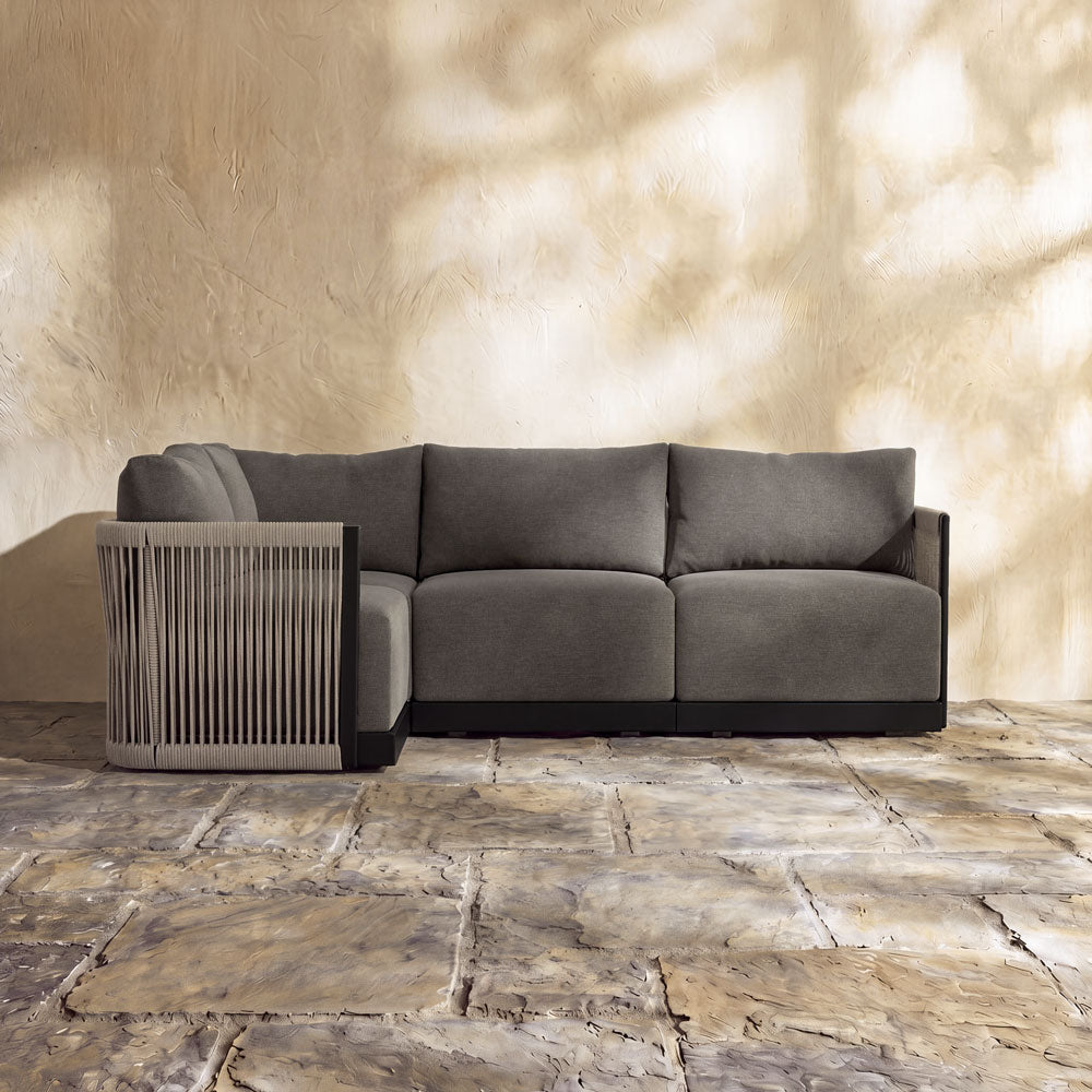 Resort 4-Seat Sectional with grey cushions and decorative rope-wrapped armrest on a stone patio.