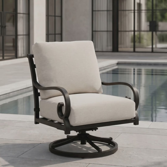 Outdoor swivel rocker patio chair with a black metal frame and cream cushions beside a modern swimming pool.
