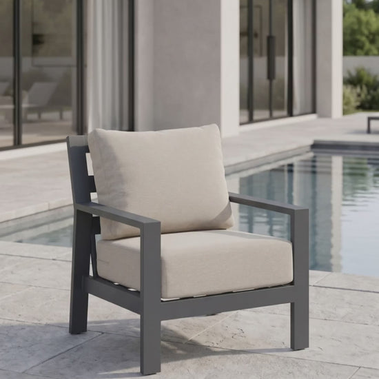 Peninsula club chair with gray aluminum frame and beige weather-resistant cushions