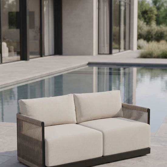 Paddy O' Furniture Resort loveseat featuring Bliss cushions on an outdoor terrace.
