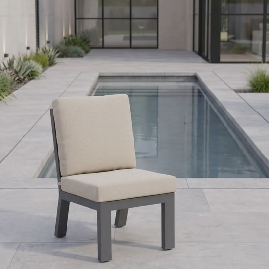 Peninsula armless outdoor dining chair with oatmeal cushions and a charcoal aluminum frame.