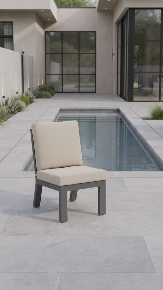 Peninsula armless outdoor dining chair with oatmeal cushions and a charcoal aluminum frame.