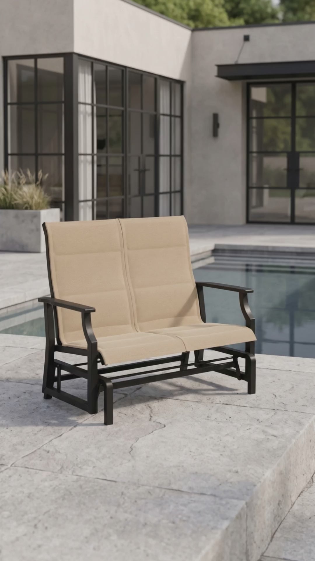 Paddy O' Furniture Newport padded sling double glider rocking on an outdoor patio.