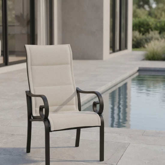 a traditional outdoor padded sling dining chair with scrolled arms