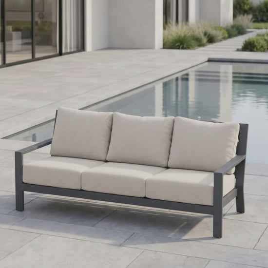 Paddy O' Furniture Peninsula outdoor sofa with Bliss cushions on a patio at sunset.