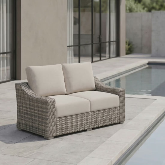 Paddy O' Furniture Loire Valley outdoor love seat with curved frame and plush cushions.
