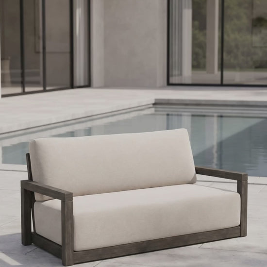 The Frame Loveseat by Paddy O' Furniture with plush Bliss cushions in a refined outdoor space.